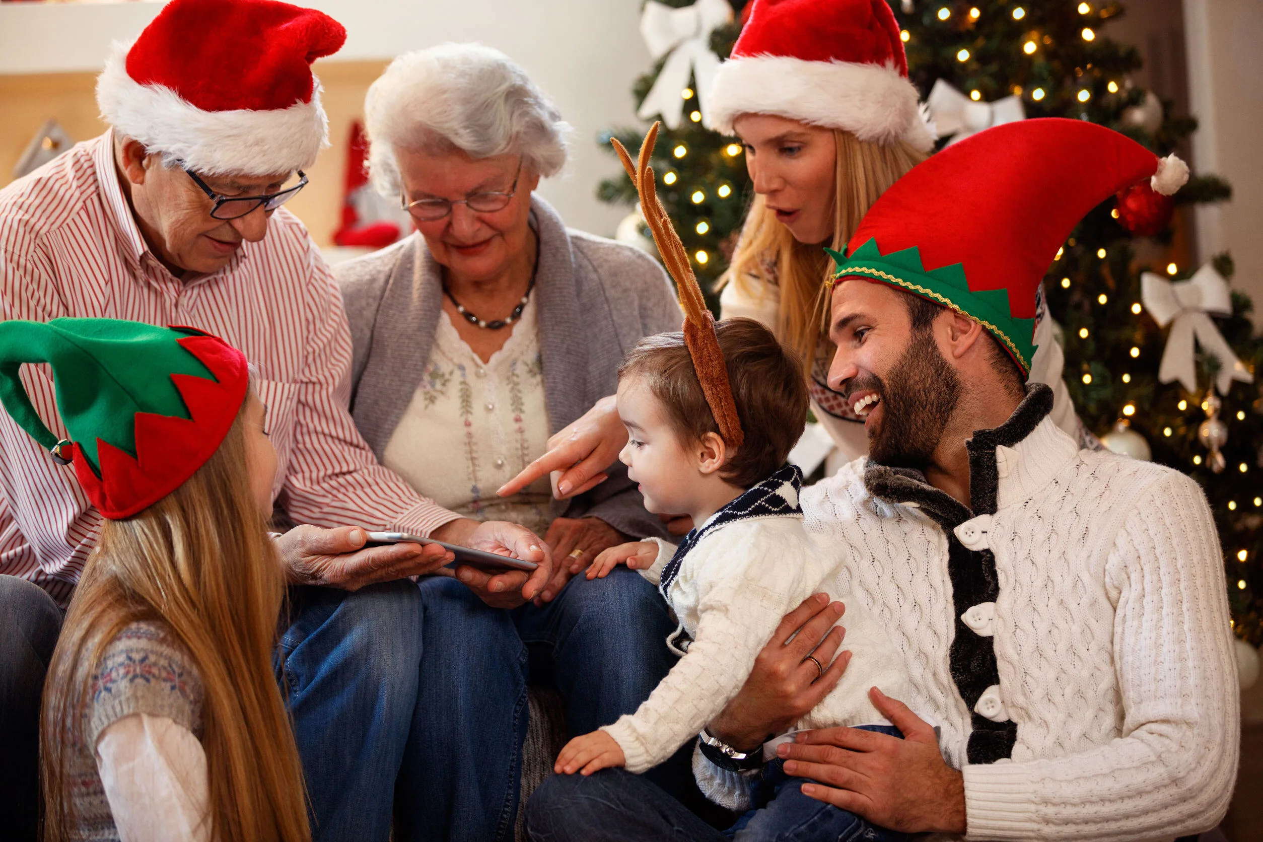 Happy family is spending time together on Christmas day and using tablet
