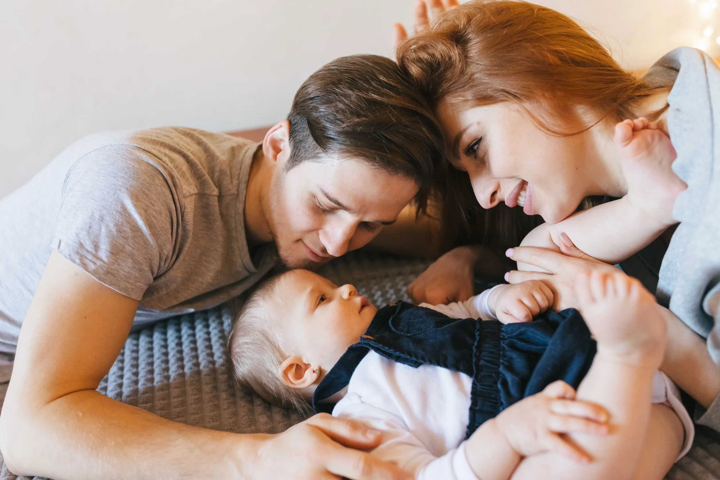 Happy family playing while lying on the sofa